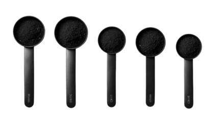 Dark powder in a row of graduated measuring cups
