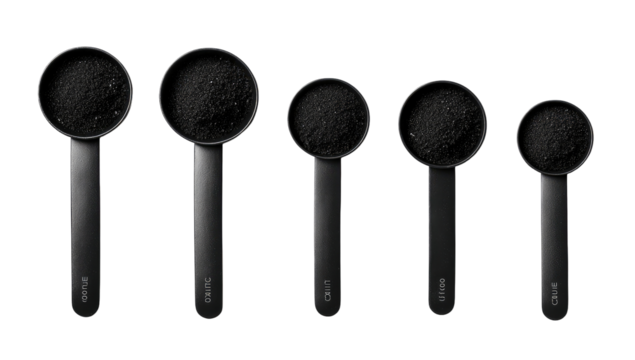 Dark powder in a row of graduated measuring cups