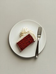 A decadent slice of red velvet cake with cream cheese frosting, served on a white plate with a fork