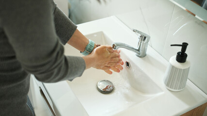 Close-Up Top View Of A Woman Washing Hands With Liquid Soap In The Bathroom