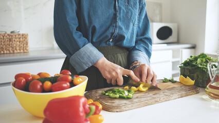 Woman Cutting Yellow Pepper For Salad