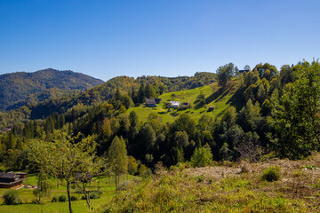 Obraz premium A green mountain landscape on a sunny day. Grassy hills and meadows of the Carpathian Mountains under a sky of glowing clouds.
