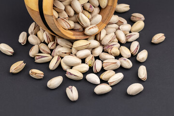 Pistachio in wood bowl on dark background