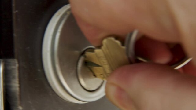 macro shot of inserting key into a lock and unlocking a door.