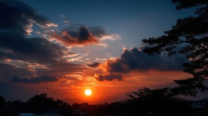 Obraz premium Majestic Sunset Over Mountains with Colorful Sky and Silhouetted Trees Capturing the Beauty of Nature in Evening Light