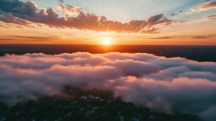 Fototapeta premium Morning sunrise over clouds covering suburban town
