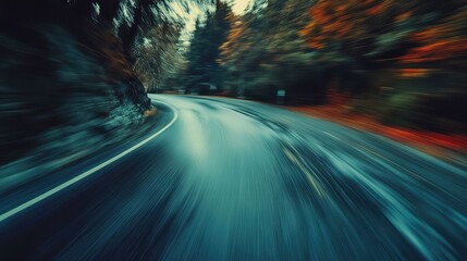 Winding road with motion blur through autumn forest