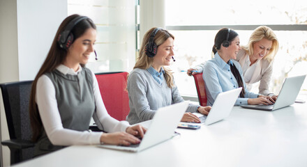 Businessman working on laptop with team behind