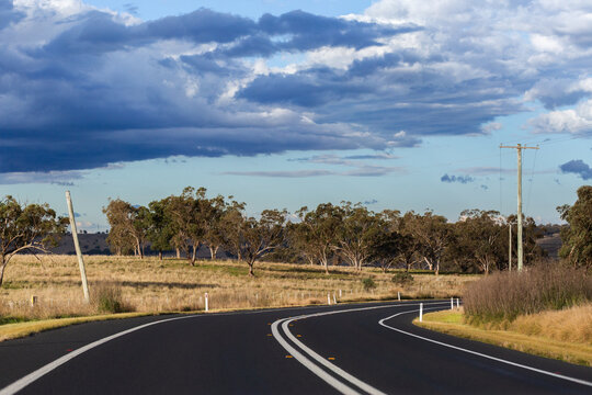 Bend in sealed road with double lines down rural highway in Australia