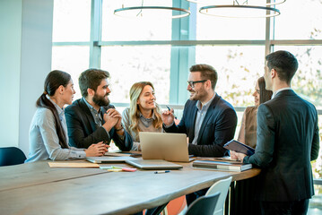 Professional business team celebrating successful collaboration around conference table