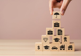 Hand placing umbrella block on top of wooden blocks stacked with insurance icons on a table