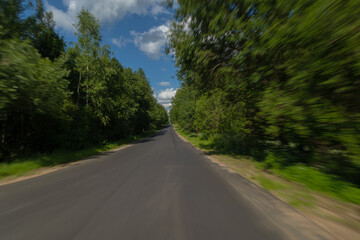 Fototapeta premium The effect of speed on the road and blur. View of the road on a summer day.
