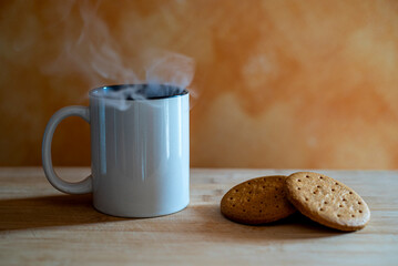 Tazza bianca fumante con biscotti su tagliere di legno con luce naturale