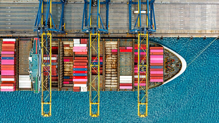 Aerial top view of cargo ship in warehouse harbor.
