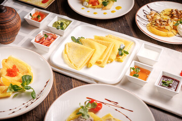 Delicious butter pancakes served with sauces in a restaurant. Gourmet breakfast with elegant presentation and rich flavor.