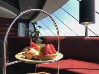 Formal elegant restaurant dining room onboard luxury cruiseship or cruise ship liner with set tables, ocean views and impressive interior inside architecture chandelier
