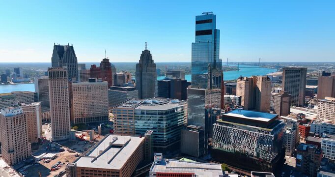 Varied multi-storied buildings and high-rises in Detroit, Michigan, USA. Blue waterscape of the Detroit River at backdrop. Aerial view.
