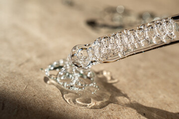 An eyedropper with a drop of oil or a cosmetic product for face and body. Natural organic cosmetics. The concept of body care.