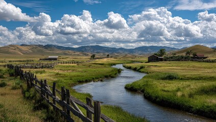 Scenic landscape with river, rolling hills, wooden fence, old buildings under a cloudy sky