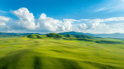 Obraz premium Green rolling hills under blue sky
