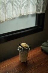 a cup of latte frape on the wood table