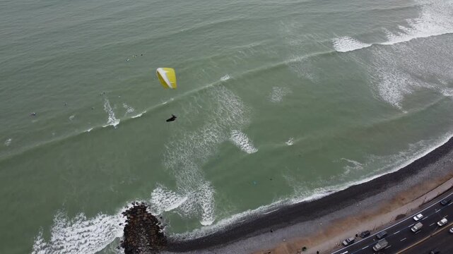 Paraglider flying over miraflores costa verde beach in lima peru