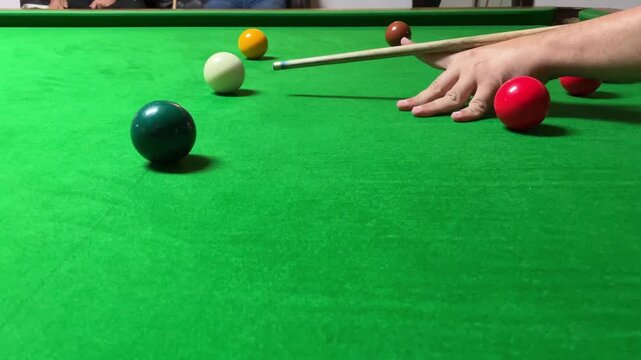 Playing a snooker shot. Indoor games. Indoor activity.