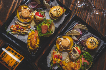 Finger sharing food on tray. Bugers, samos. Kolacja. 