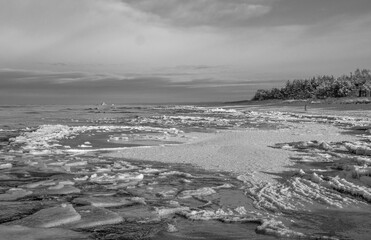 winter seascape showing frozen sea ice with cracked sheets and textured snow on the surface. Natural icy patterns and frozen water landscape in cold climate.	