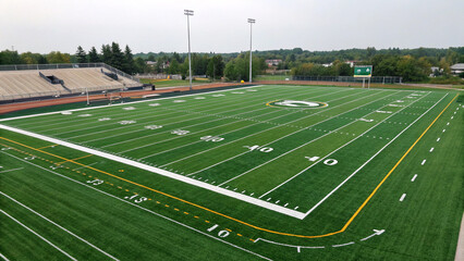Obraz premium An American football field, showcasing a meticulously maintained green grass surface, marked with white yard lines and numbers