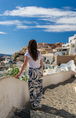 Fototapeta premium Mujer feliz disfrutando el paisaje en la isla griega de Santorini en el mar Mediterráneo. Viajes y turismo