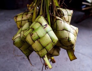 Close-up of traditional woven ketupat hanging with warm lighting, symbol of Eid al-Fitr celebration.