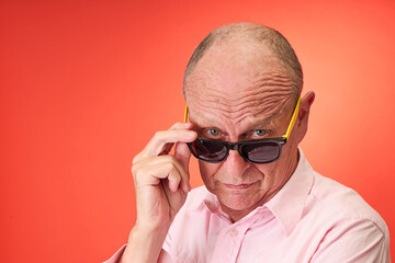 Closeup portrait of a elderly man in studio wearing sunglasses