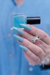 beautiful hand with long nails and light baby blue manicure
