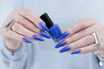 Woman's beautiful hand with long nails and blue manicure