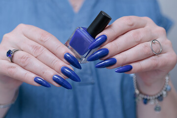 Woman's beautiful hand with long nails and bright blue manicure 