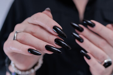 Female hands with long nails and black nail polish
