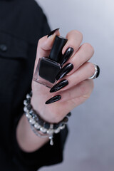 Female hands with long nails and black nail polish