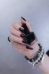 Female hands with long nails and black nail polish