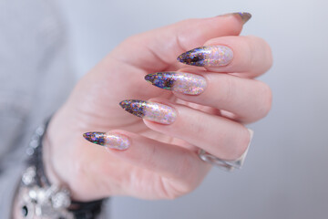 Female hands with long nails and white and black thermo french manicure