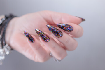 Female hands with long nails and black nail polish