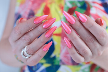 beautiful female hands with long nails and bright neon pink red nail polish