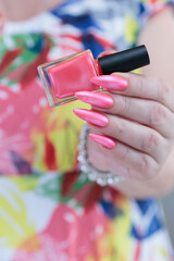 beautiful female hands with long nails and bright neon pink red nail polish