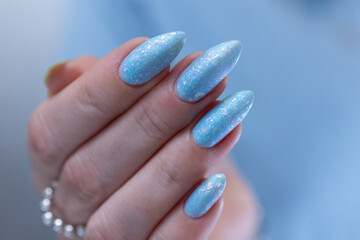 Woman's beautiful hand with long nails and bright blue manicure