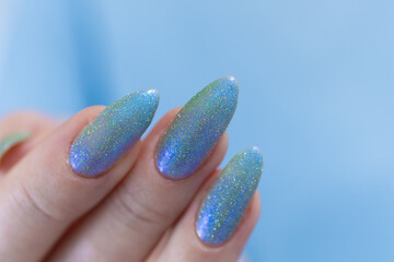 Woman's beautiful hand with long nails and light baby blue manicure	