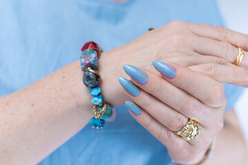 Woman's beautiful hand with long nails and light baby blue manicure	