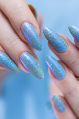 Woman's beautiful hand with long nails and bright blue manicure