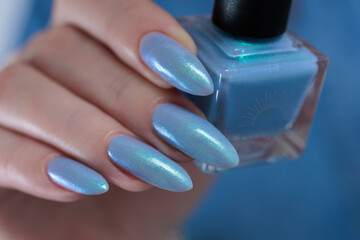 Woman's beautiful hand with long nails and bright blue manicure