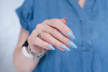 Woman's beautiful hand with long nails and light baby blue manicure	