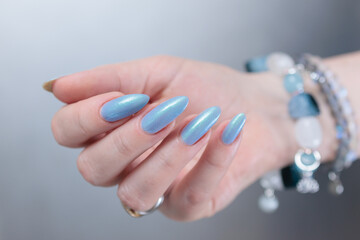 Woman's beautiful hand with long nails and light baby blue manicure	
